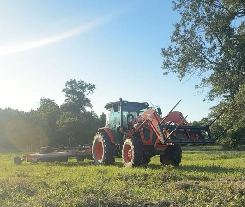 Tractor and mower in a field