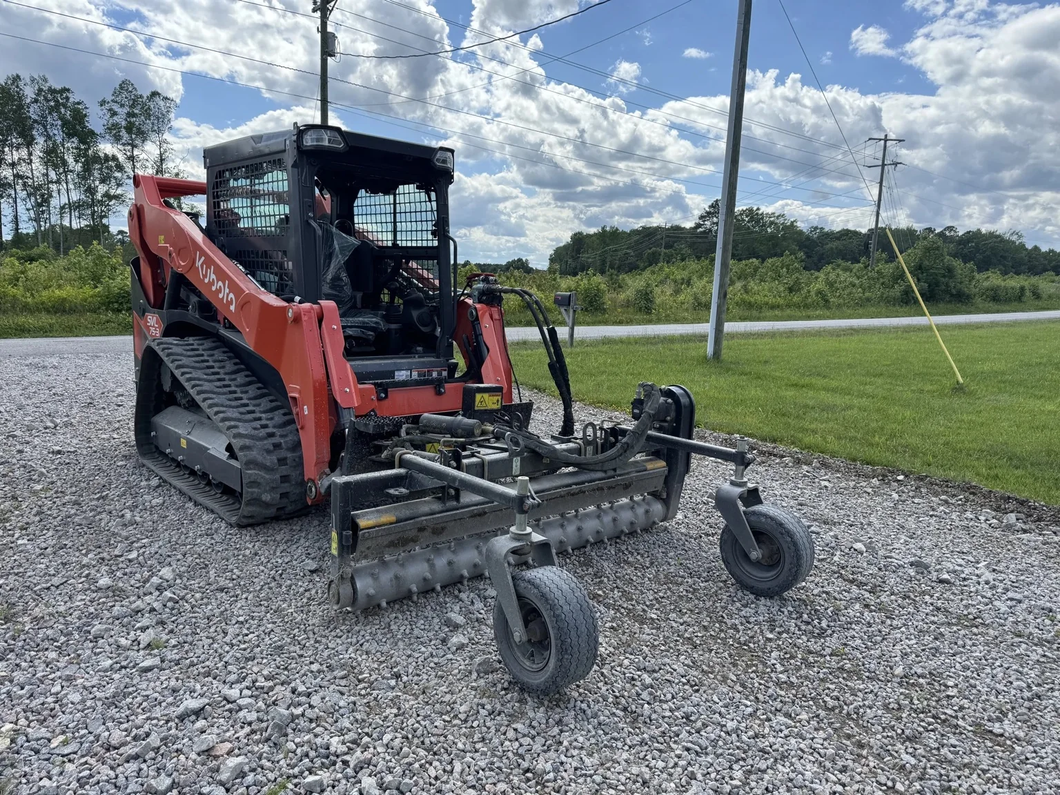Kubota skid steer working on a rock road